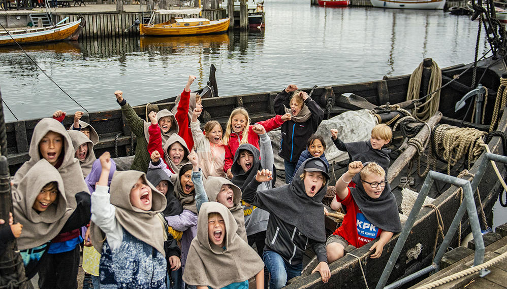 Børn klædt ud som vikinger i en båd