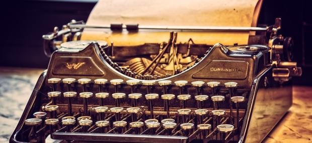 En gammeldags skrivemaskine med et gulnet papir i