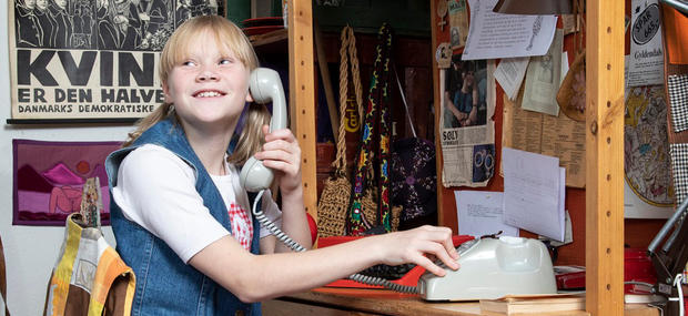 En pige snakker i en drejeskivetelefon fra 1970'erne