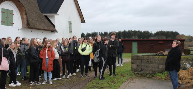 En skoleklasse vises rundt på Museumsgården Karensminde