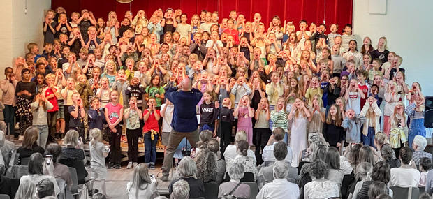 Billede fra SkoleKordagen 2022 med Jakob Høgsbro som instruktør. 200 børn synger sammen.