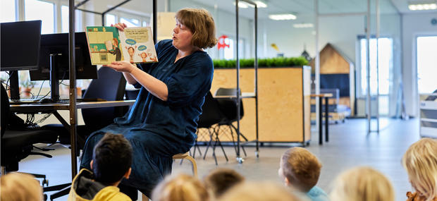 Bibliotekar læser højt for en gruppe børn.