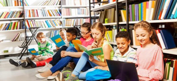 en gruppe elever sidder blandt bibliotekets reoler og løser opgaver