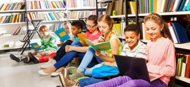 en gruppe elever sidder blandt bibliotekets reoler og løser opgaver