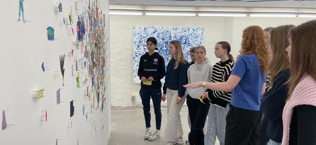 En klasse går rundt sammen med en kunstformidler og snakker om udstillingerne