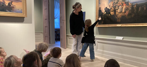Børn kigger på maleri på museum.