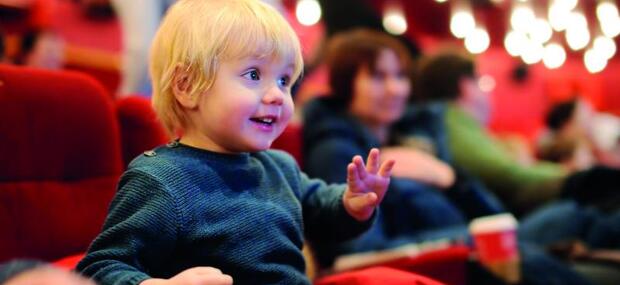 Begejstret lille dreng sidder i biografstol