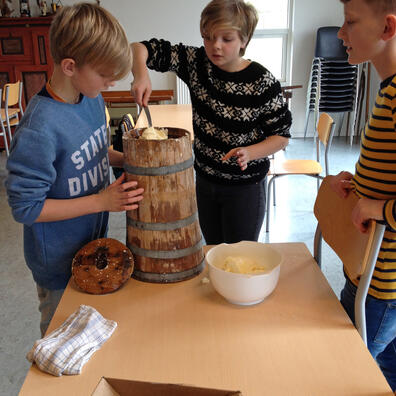 Der bliver kærnet smør på de gamle stampekærner.