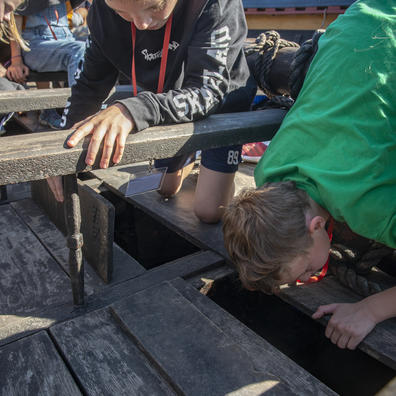Elev undersøger vikingeskib på Vikingeskibsmuseet