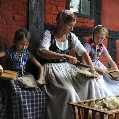 Madmor lærer småpigerne at karte. 