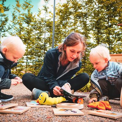 Børn og voksen går på opdagelse i haven