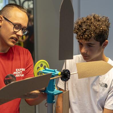 Vores piloter i de røde trøjer guider og hjælper eleverne i værkstedet.