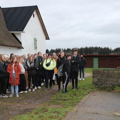 En skoleklasse vises rundt på Museumsgården Karensminde