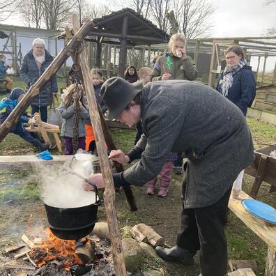 Der koges suppe i jerngryden over bålet.
