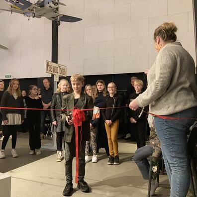 Elev klipper det røde bånd og erklærer udstillingen for åben.