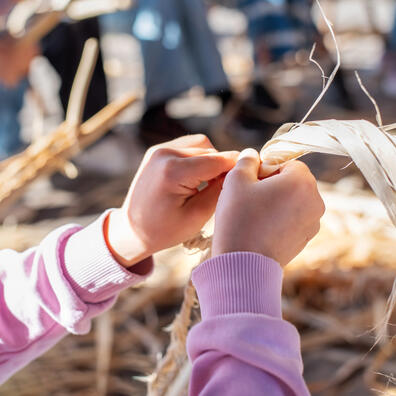 Billedet viser hænderne på en elev, der er ved at lave et reb. 