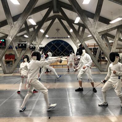 I fægter på rigtige konkurrencebaner med elektrisk markering og med fægteudstyr på. 