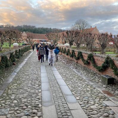 Tjenestepigen leder eleverne ind på herregården