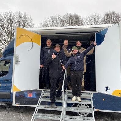 Billede af bilen "Karlsvognen", med åben vogn og glade formidlere.