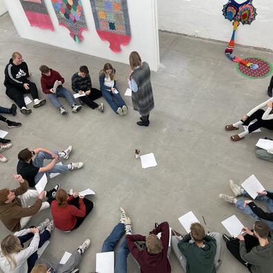 En skoleklasser går rundt i udstillingen og snakker om værkerne