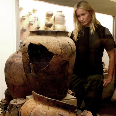 kvinde ser på lerkar i udstilling