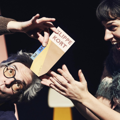 En pige og hendes morfar holder et klippekort imellem sig og er glade