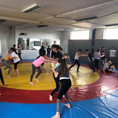 Børn leger slåslege på madras.